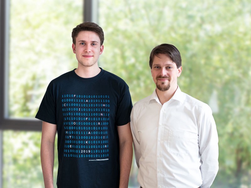 Zwei junge Männer stehen vpr grünem Hintergrund 