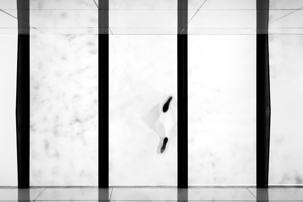 Blick von unten auf zwei Füße auf einem Glasdach